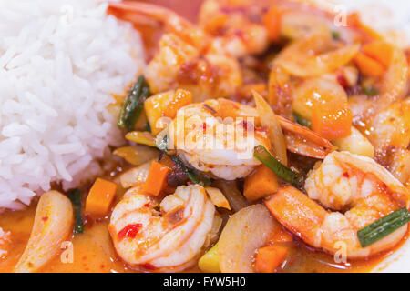 unter Rühren gebratene Garnelen in thai rotem Curry paste mit Reis und Spiegelei, würzig gebratene Garnelen, Curry gebratene Garnelen und gekochten Reis in Stockfoto