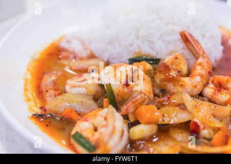 unter Rühren gebratene Garnelen in thai rotem Curry paste mit Reis und Spiegelei, würzig gebratene Garnelen, Curry gebratene Garnelen und gekochten Reis in Stockfoto
