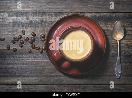 Tasse Kaffee und Bohnen auf Grunge Eiche Holz Hintergrund Stockfoto