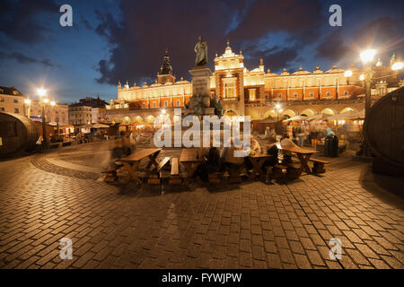 Polen, Stadt von Krakau bei Nacht, Tuchhallen - mittelalterliche Einkaufszentrum Sukiennice, Adam Mickiewicz Denkmal, Menschen bei Outdoor-caf Stockfoto