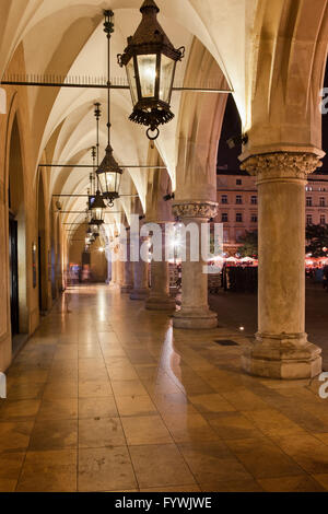 Polen, Stadt von Krakau, Old Town, Tuchhallen - Sukiennice Kolonnade mit Laternen in der Nacht Stockfoto