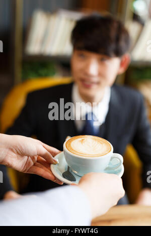 Kellnerin für junge Kunden im Café serviert Stockfoto