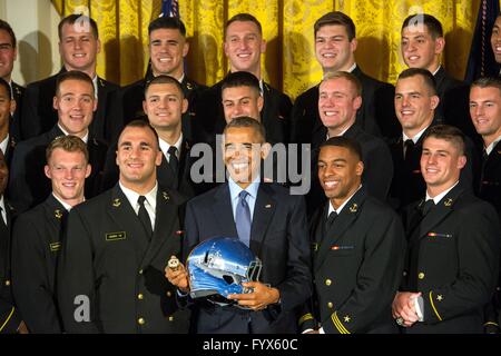 Washington DC, USA. 27. April 2016. US-Präsident Barack Obama hält einen Navy Football Helm und Ring nach der Vergabe der Kommandant in Chefs Trophy während einer Zeremonie im Weißen Haus 27. April 2016 in Washington, DC. Stockfoto