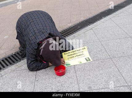 Bettler, die auf dem Boden liegend Stockfoto