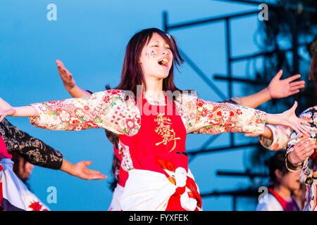 Nahaufnahme des jungen japanischen Frau Tänzer, ein Teil der Mannschaft, durch Strahler beleuchtet, Arme ausgestreckt, Gesang während der jährlichen yosakoi Dance Festival. Stockfoto
