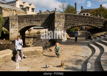 Großbritannien, England, Yorkshire, Calderdale, Hebden Bridge, kleines Kind, die Jagd auf Enten unter alten Lastesel Brücke Stockfoto