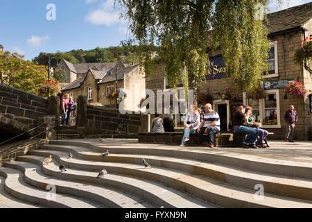 Großbritannien, England, Yorkshire, Calderdale, Hebden Bridge, Bridge Gate Besucher saßen am wellig Schritte neben alten Lastesel Brücke Stockfoto