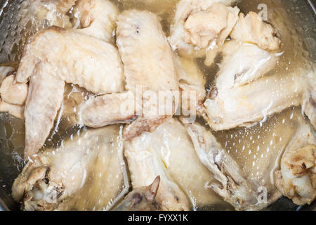 viele gekochte Hähnchenflügel in fettigen Hühnerbouillon in bietet Stockfoto