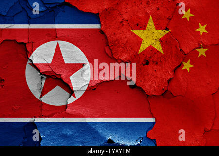 Flagge von Nordkorea und China auf rissige Wand gemalt Stockfoto