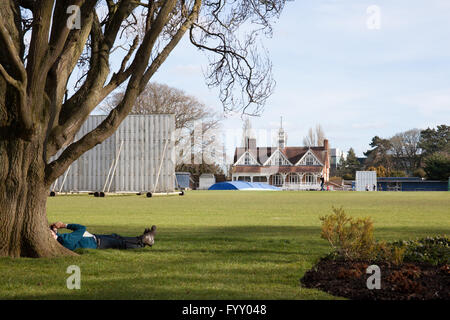 Ein Mann unter einem Baum an der Oxford University Parks faulenzen. Stockfoto