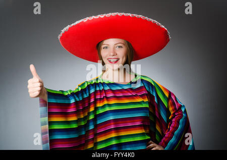 Mädchen im mexikanischen lebendige Poncho gegen grau Stockfoto