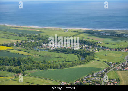 Eine breite Luftaufnahme der Northumberland Dorf Warkworth, zeigt die Küste und Warkworth Castle Stockfoto