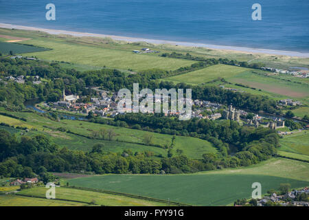 Eine breite Luftaufnahme der Northumberland Dorf Warkworth, zeigt die Küste und Warkworth Castle Stockfoto