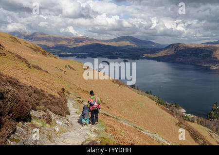 Eine Mutter mit einem Baby auf dem Rücken und ihr Sohn zu Fuß absteigen Katze Glocken im Lake District, England Stockfoto