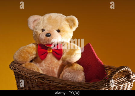 Teddy Bär sitzt im Weidenkorb Stockfoto