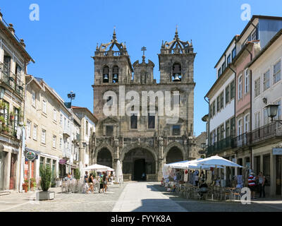 Straßenszene mit Menschen, Straßencafé, Souvenir-Shop und Kathedrale Santa Maria in der alten Stadt von Braga, Portugal Stockfoto