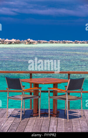 Stühle und Tisch auf tropischen Insel mit Sandstrand, Palmen und Tourquise klares Wasser Stockfoto