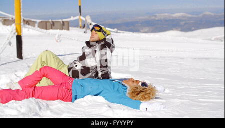 Paar ruht auf Hügel nach dem Skifahren Stockfoto