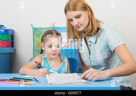 Mentor zeigt fünf Kinder Briefe richtig schreiben Stockfoto