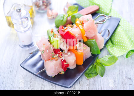 rohes Hühnchen Kebab auf Teller und auf einem Tisch Stockfoto