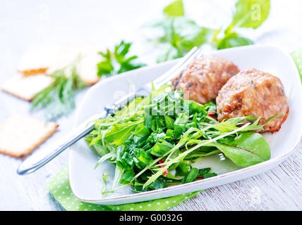 Schnitzel mit Salat auf Teller und auf einem Tisch Stockfoto