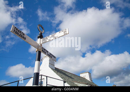 Walisische Sprache schwarz-weiß Vintage Gusseisen gegenüberstehenden Aberdaron, Pwllheli gegen blau bewölktem Himmel zeigen Richtungen geschossen Stockfoto