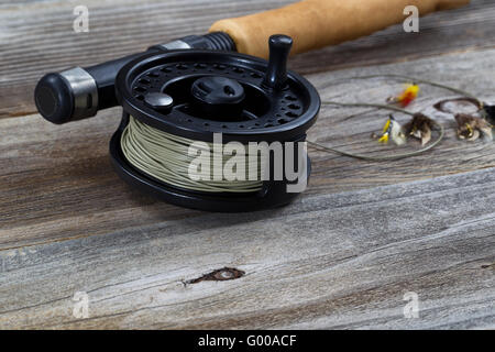 Nahaufnahme von Fly Reel und fliegt auf Holz Stockfoto