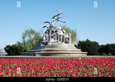 Washington, DC - The Navy-Merchant Marine Memorial, an den Ufern des Potomac und nicht weit von das Pentagon ist umgeben von roten Tulpen, die im Frühjahr blühen. Er sitzt weiter auf Columbia Insel entlang der George Washington Memorial Parkway. Stockfoto