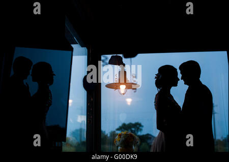 Silhouetten von Braut und Bräutigam auf dem Hintergrund des Fensters Stockfoto