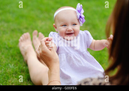 Mutter Holding niedlichen Kind in Händen. kleines Baby liegend in übergeordneten Stockfoto