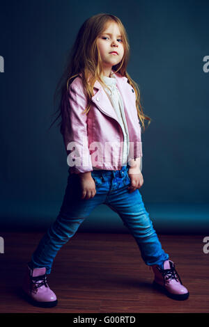 schönes Kind trägt Jeans und Lederjacke im studio Stockfoto