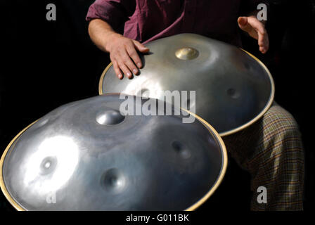 Schlagzeuger spielen die Hang Steel Drum mit schwarzem Hintergrund Stockfoto