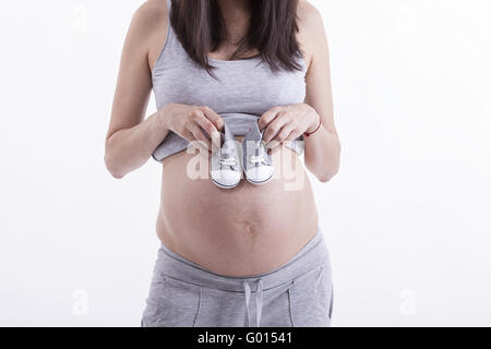 Kleine Schuhe für das ungeborene Kind Stockfoto