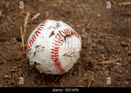 Alte rote und weiße robuste Baseball auf einem Boden von Schmutz Stockfoto