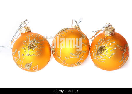 Drei goldene Weihnachtskugeln. Isoliert auf weiss Stockfoto