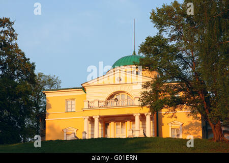 Herrenhaus im klassischen Stil auf einem Hügel, umgeben von Park. In den Strahlen der Abendsonne Stockfoto