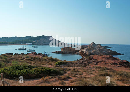 Menorca: Roter Sand auf dem Weg zur Cala Pregonda, einsamen Bucht mit Felsen, eine Landschaft wie der Planet Mars Stockfoto