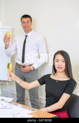 Schlägt einen Toast am Arbeitsplatz für einen wirtschaftlichen Erfolg zu feiern Stockfoto