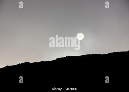 Blick auf Bergrücken mit Sonne schwach durch Wolke Mynydd Mawr Aberdaron Gwynedd North Wales UK Stockfoto