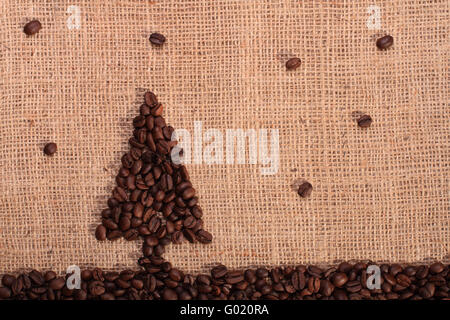 Weihnachtsbaum und Sterne aus gerösteten Kaffeebohnen mit auf Sackleinen Hintergrund Stockfoto