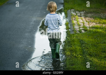 Junge in einer Pfütze Stockfoto