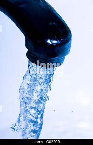 Wasser vom Wasserhahn in blauer Farbe Stockfoto