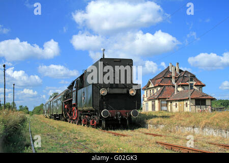 Alten Retro-Dampfzug daran hinderte, dem kleinen Bahnhof Stockfoto