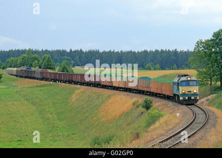 Güterzug mit Diesellok, die hügelige Landschaft vorbei an geschleppten Stockfoto