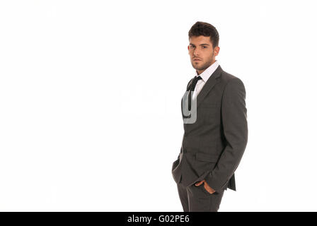 Junger Geschäftsmann mit textfreiraum ernst die Hände in den Taschen isoliert auf weißem Hintergrund Stockfoto