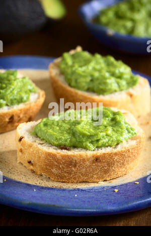 Frische Avocado Creme oder Guacamole auf Brot Zwiebelscheiben, fotografiert mit natürlichem Licht (Tiefenschärfe) Stockfoto