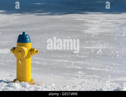 gelb und blau Hydranten im Schnee Stockfoto