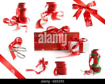 Verschiedene Größen von roten Bändern und wickelte Geschenkboxen isoliert auf weiss Stockfoto