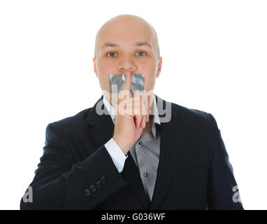 junger Geschäftsmann mit einem Finger an den Mund. Stockfoto