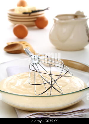 Vanilny Sauce in eine Schüssel und Schneebesen für Peitschen. Stockfoto